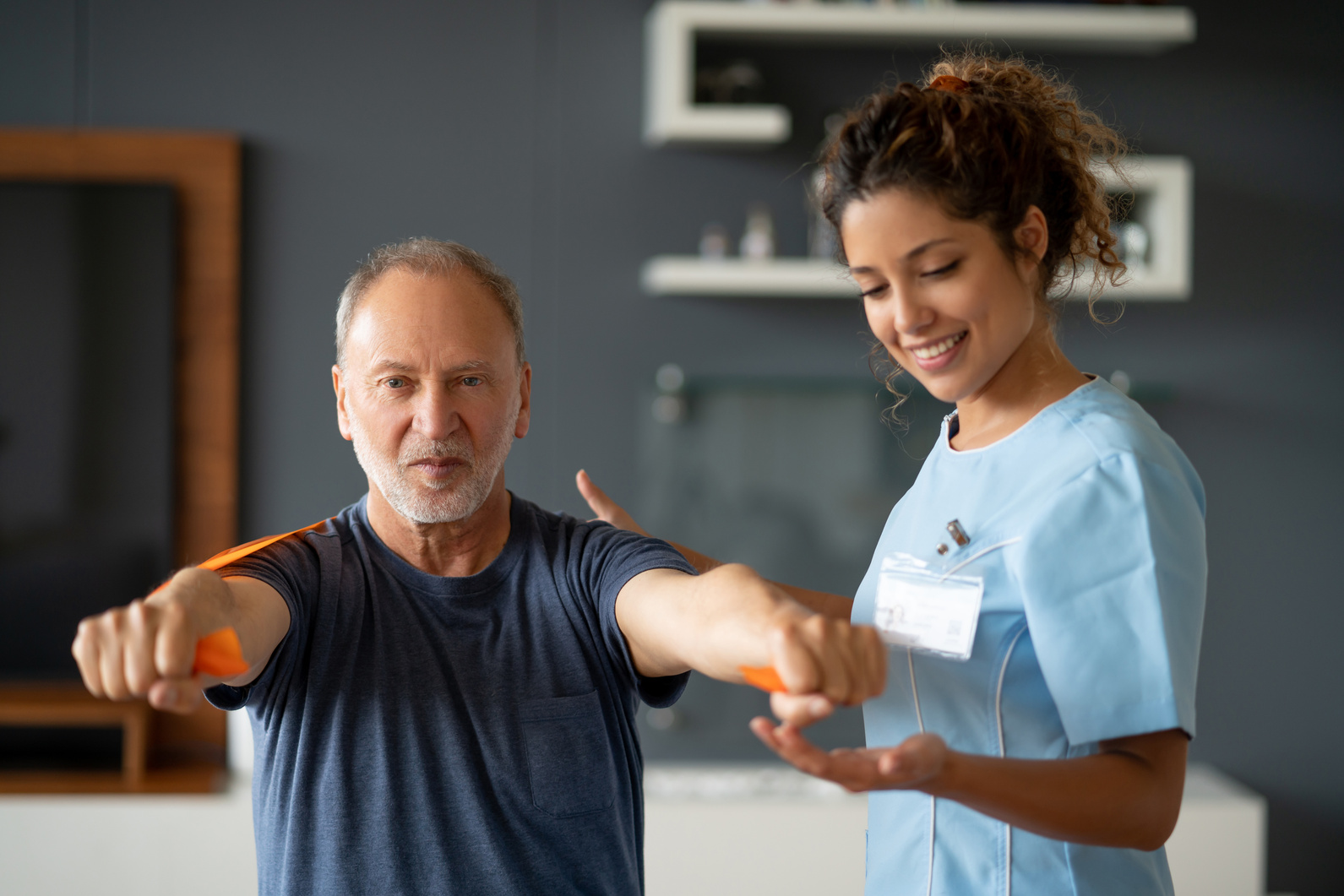 Home caregiver helping a senior man with his physiotherapy